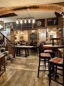 a restaurant with tables and chairs in a room at The George Hotel in Castle Cary