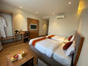 a hotel room with two beds and a table at Landmark Narayani in Chitwan