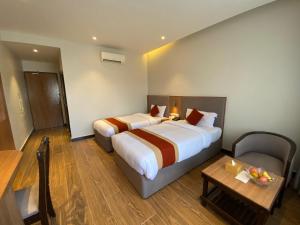 a hotel room with two beds and a table at Landmark Narayani in Chitwan +15 photos
