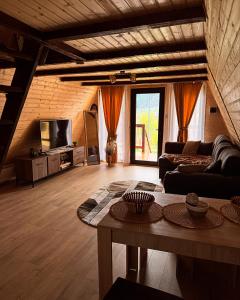 a living room with a couch and a table at Căsuțele EliMar in Chirleşti