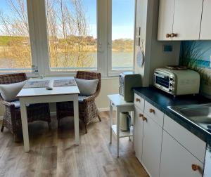 a kitchen with a table and a sink and a microwave at lüttjeseeblick13 in Nordstrand