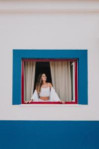 a woman is looking out of a window at Herdade da Cova da Onça in Canha