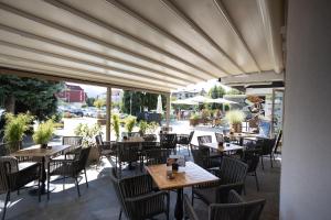 ein Restaurant mit Tischen und Stühlen und einem großen Fenster in der Unterkunft MC Hotel in Žalec