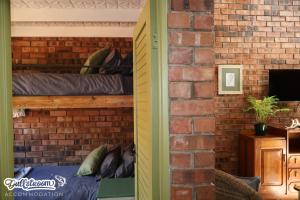 a brick walled bedroom with a bunk bed in it at Olive Branch in Dullstroom