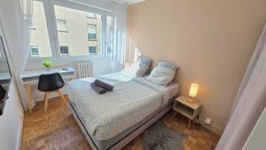 a small bedroom with a bed and a window at Le Repaire - Hyper centre, 3 ch, balcon et parking in Le Mans