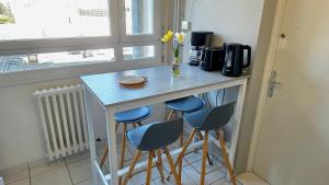 a kitchen with a counter with three stools and a table at Le Repaire - Hyper centre, 3 ch, balcon et parking in Le Mans +12 photos