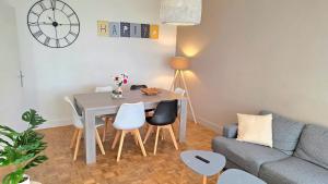 a living room with a table and chairs and a couch at Le Repaire - Hyper centre, 3 ch, balcon et parking in Le Mans