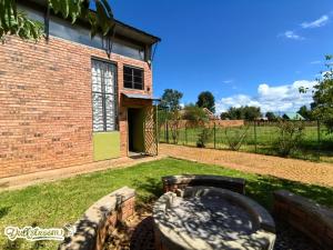 a brick building with a fire pit in the yard at Olive Branch in Dullstroom