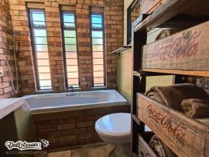a bathroom with a bath tub and a toilet at Olive Branch in Dullstroom +13 photos