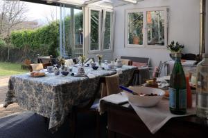 a dining room with two tables and a bottle of wine at Lùlù Guest House in Dernice