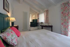 a bedroom with a white bed and a green chair at Lùlù Guest House in Dernice
