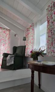 a living room with a green chair and a table at Lùlù Guest House in Dernice