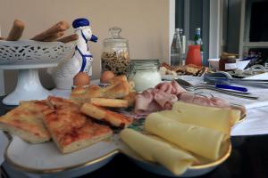 a table with a plate of food with bread and cheese at Lùlù Guest House in Dernice +23 photos
