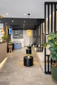 a lobby with tables and potted plants at Bayer's City Hotel in Munich