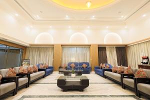 a waiting room with blue couches and a table at Hotel Nivaara By VYDA in Tirupati