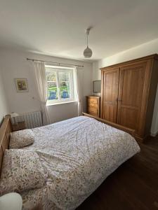 a bedroom with a bed and a dresser and a window at Gîte de Lasdoumingeas in Ladignac-le-Long