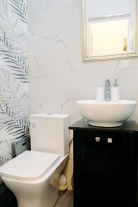 a bathroom with a white toilet and a sink at Nuance Residences - Cresento in Volos +2 photos