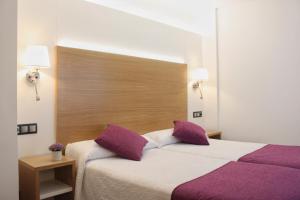 a bedroom with a large bed with purple pillows at Hotel La Noyesa *** Superior in O Grove