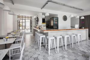 a restaurant with a bar with white stools at Hotel Alto San Isidro in San Isidro