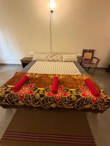 a bedroom with a bed with red and brown sheets at Bliss Stay in Mūvattupula