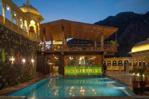 a hotel with a swimming pool in front of a building at BADIGARH RESORT - Udaipur in Thūr