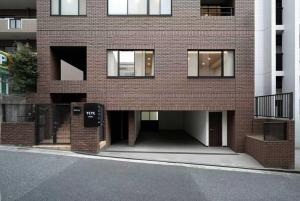 a brick building with a sign in front of it at YCYC Hotel in Tokyo