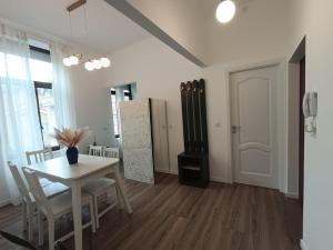 a dining room with a table and a refrigerator at Zion Central Apartment in Satu Mare