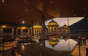 a restaurant with tables and chairs in front of a building at BADIGARH RESORT - Udaipur in Thūr
