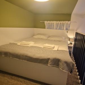 a bed with two towels on top of it at Zion Central Apartment in Satu Mare