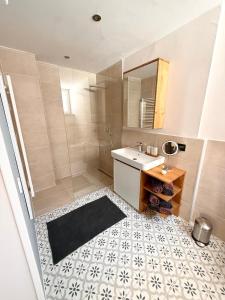 a bathroom with a sink and a shower with a mirror at Ferienwohnung Schneider-Beiwinkel in Edenkoben