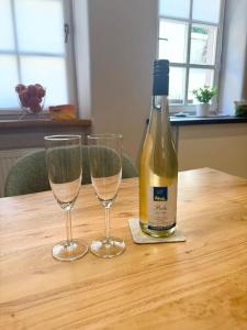 a bottle of wine and two glasses on a table at Ferienwohnung Schneider-Beiwinkel in Edenkoben +5 photos