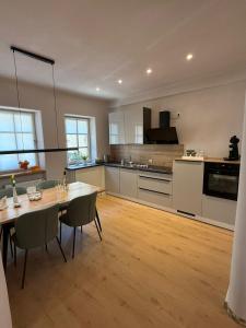 a kitchen with a dining table and a kitchen with white cabinets at Ferienwohnung Schneider-Beiwinkel in Edenkoben