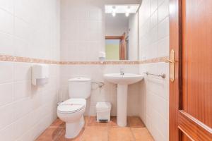 a white bathroom with a toilet and a sink at Hotel El Horno in La Puebla de Valverde +39 photos