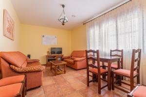 a living room with furniture and a table and chairs at Hotel El Horno in La Puebla de Valverde