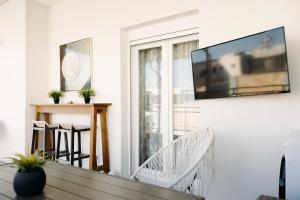 a living room with a tv on the wall at Nuance Residences - Cresento in Volos