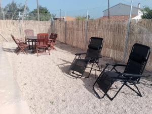 a group of chairs and a table and a fence at Casa Carme in Camarles