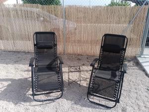 two black folding chairs sitting next to each other at Casa Carme in Camarles