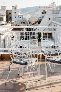 a white table and chairs on a balcony at Nuance Residences - Cresento in Volos