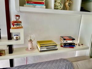 a shelf with books on it with a bed at Casa Le Campane sulla Via Francigena in Gambassi Terme