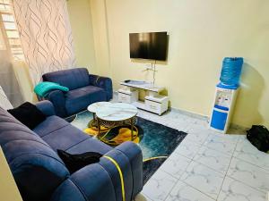a living room with a blue couch and a tv at The perfect Hideout in Nairobi
