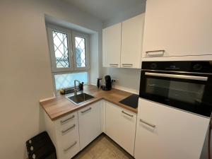 a kitchen with white cabinets and a sink and a microwave at Ferienwohnung historisches Teisendorf in Teisendorf