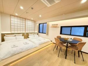 a bedroom with a large bed and a table at YCYC Hotel in Tokyo