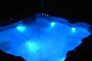 a blue pool of water with lights in it at VILLA du VERNET avec JACUZZI in Vernet