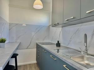 a kitchen with blue cabinets and a sink at Adrijana 2 in Krk +24 photos