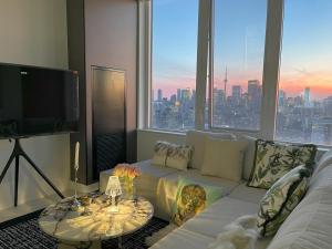 a living room with a white couch and a large window at Luxurious Panoramic Skyline Penthouse 2Bedrooms Suites CN Toronto Downtown in Toronto