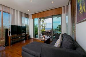 a living room with a couch and a flat screen tv at Kata Gardens Penthouse sea view 4C near Kata Noi Beach in Kata Beach