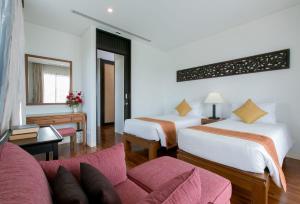 a hotel room with two beds and a couch at Kata Gardens Penthouse sea view 4C near Kata Noi Beach in Kata Beach +66 photos