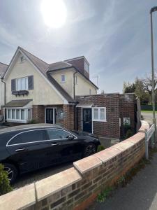 a black car parked in front of a house at Brand New One Bedroom Apartment in Hendon