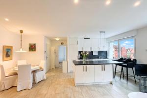 a kitchen and living room with white cabinets and a table at Loft Nagoldtal in Pforzheim