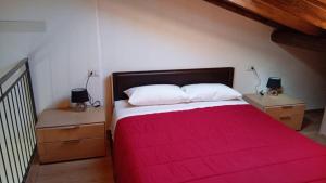 a bedroom with a large bed with a red blanket at Appartamento Trezzo sull'Adda in Trezzo sullʼAdda